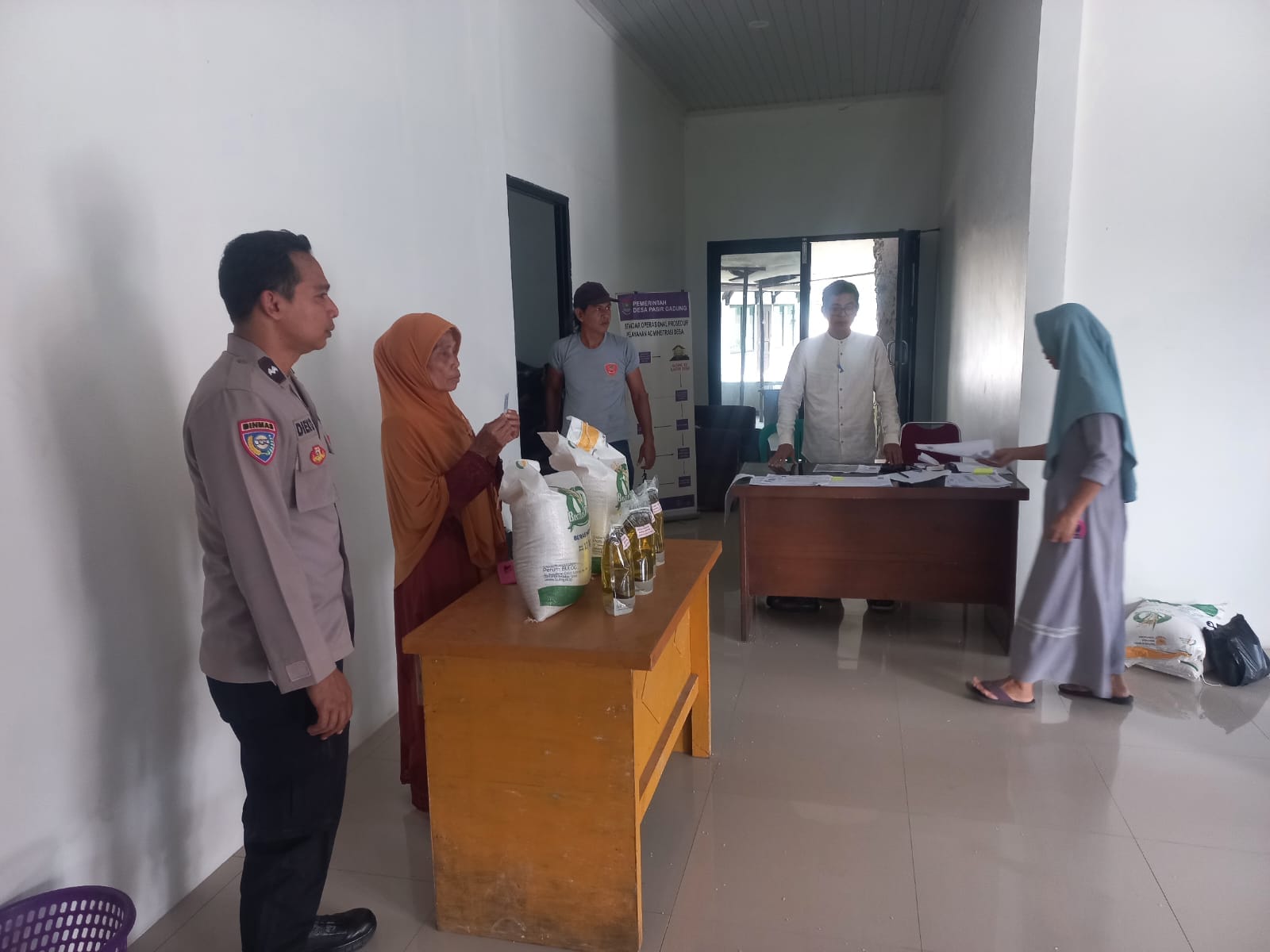 Polsek Cikupa Awasi Penyaluran Bantuan Pangan Bulog di Desa Pasir Gadung
