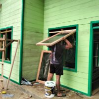 Hampir Rampung, Anggota Satgas TMMD Pasang Jendela RTLH di Kampung Linggang Amer